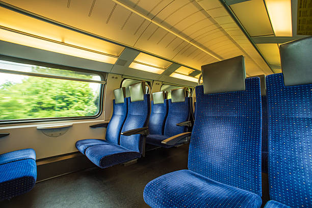 istock Empty blue cloth seats inside passenger train in Europe. Large window side seats, moving train, blurred exterior rural  background, no people 2217305692