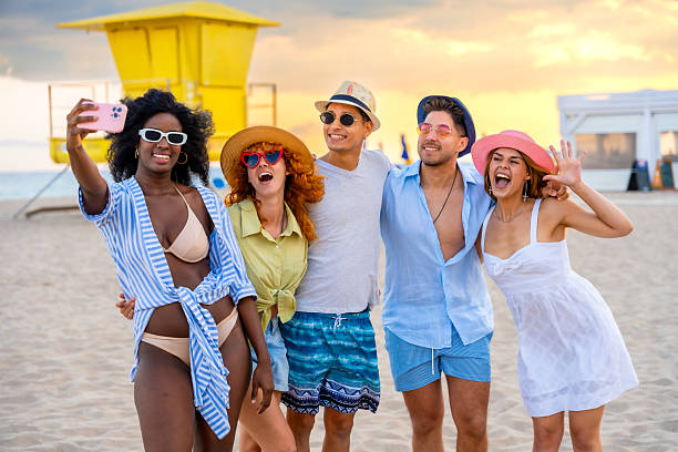 istock Happy friends taking selfie on the beach at sunset 2217306478