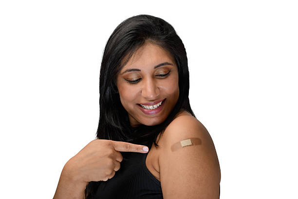 istock woman points to the vaccine sticker on her arm 2217309927