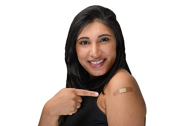 istock woman points to the vaccine sticker on her arm 2217309961