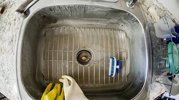 istock Cleaning process in a kitchen sink with dish rack and cleaning brush 2217312049