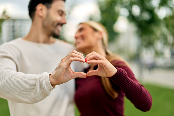 istock Romantic couple making heart shape with hands outdoors 2217315427