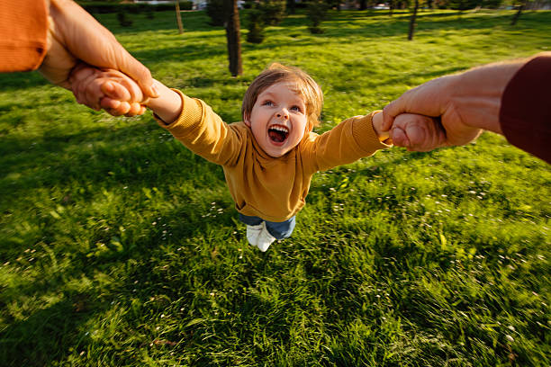 istock Child Laughing While Being Spun in Park 2217316365