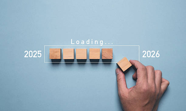 istock A hand places the final wooden block in a progress bar marked “Loading…” between the years 2025 and 2026, symbolizing transition, planning, and progress into the new year concept. 2217316780