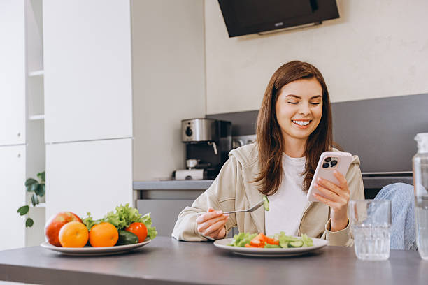 istock Woman enjoying healthy meal and using smartphone in modern kitchen 2217321529