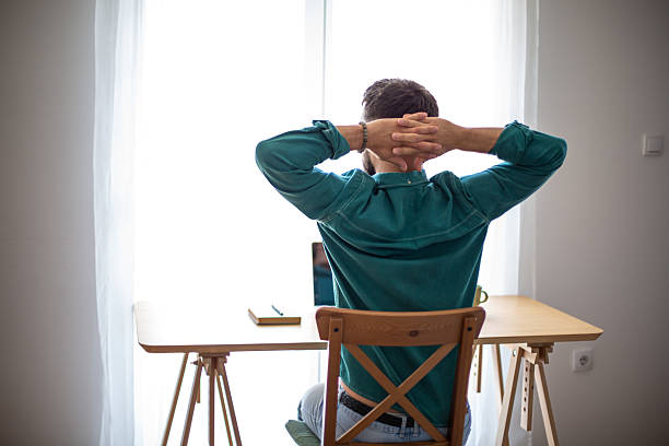 istock Freelancer relaxing and stretching at home office desk 2217322741