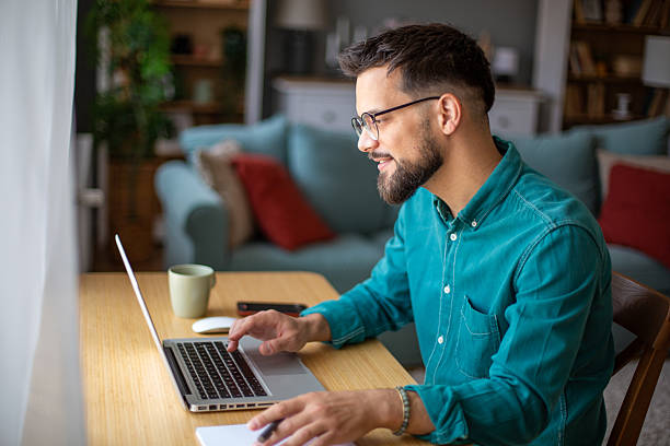 istock Young businessman working from home, taking notes while looking at laptop 2217323912