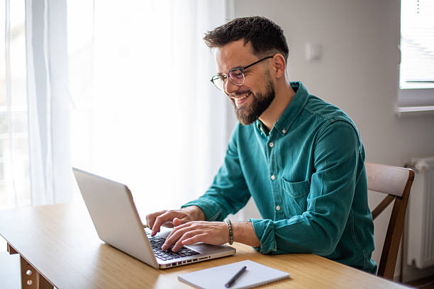 istock Young businessman working from home typing on a laptop and smiling 2217324203