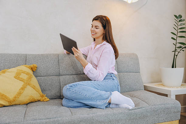 istock Young Woman Relaxing on Sofa Using Digital Tablet at Home 2217324289