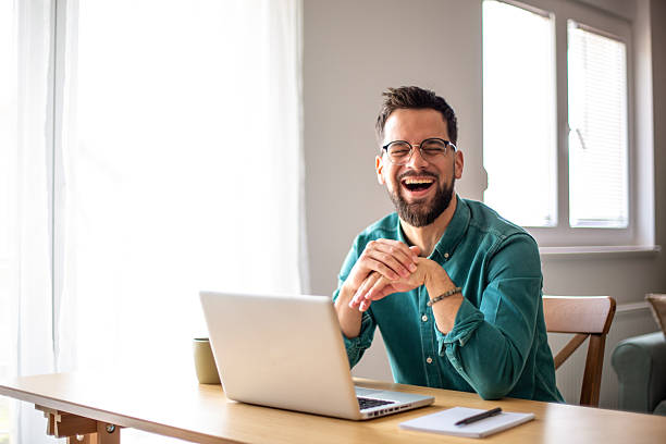 istock Young businessman laughing while working from home office 2217325351