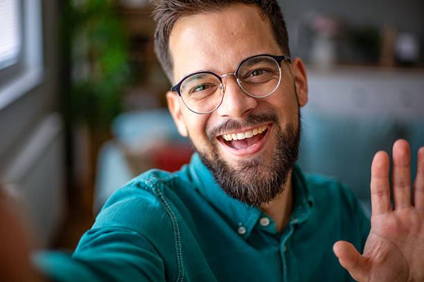 istock Young man with glasses taking a selfie and waving 2217325598