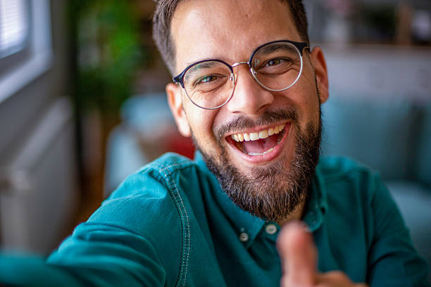 istock Happy young man taking a selfie and giving thumbs up 2217325743