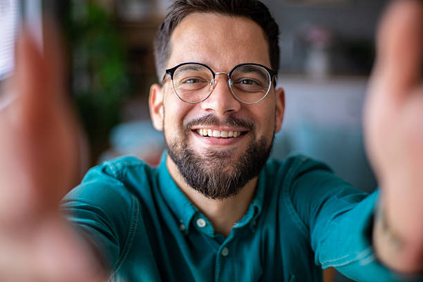 istock Smiling young man taking selfie with outstretched hands 2217326114
