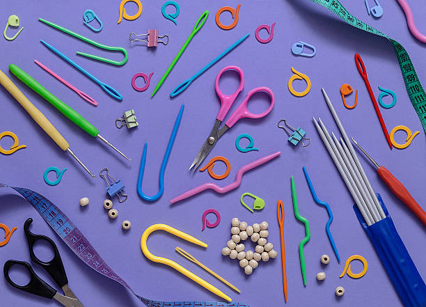istock Knitted and crocheted tools on a purple background. Top view. 2217327756