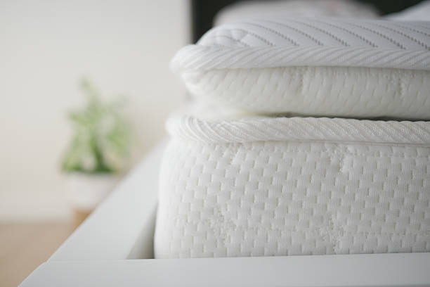 Cozy white bedding stacked on a modern bed frame in a bright room