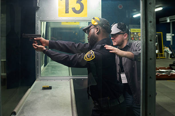 istock Instructor Demonstrating Pistol Shooting at Indoor Range 2217328017