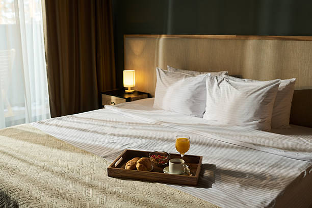 istock Breakfast Tray on Cozy Hotel Bed with Soft Pillows 2217330156