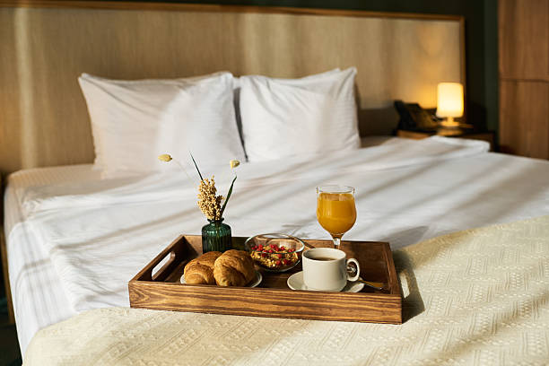 istock Breakfast Tray on Bed with Fresh Orange Juice and Croissants 2217330158