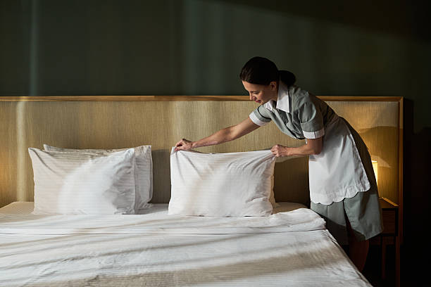 istock Making Bed in a Clean Modern Hotel Room 2217330161