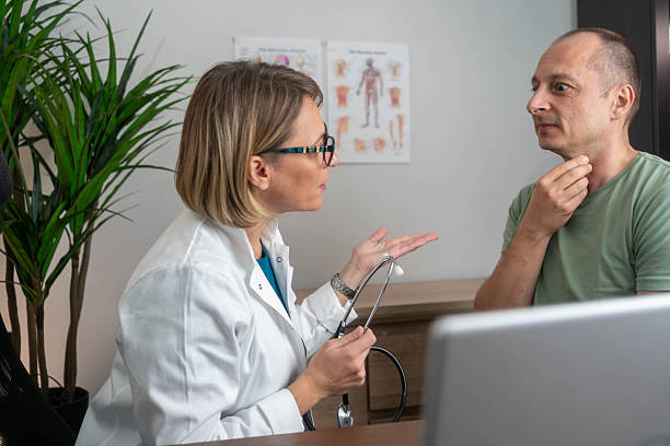 istock Female doctor doing throat examination on mature man 2217331102