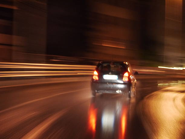 Car is driving down a wet road at night