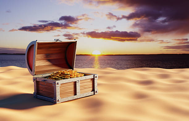 istock Chest with treasures on sand against the sunset 2217332191