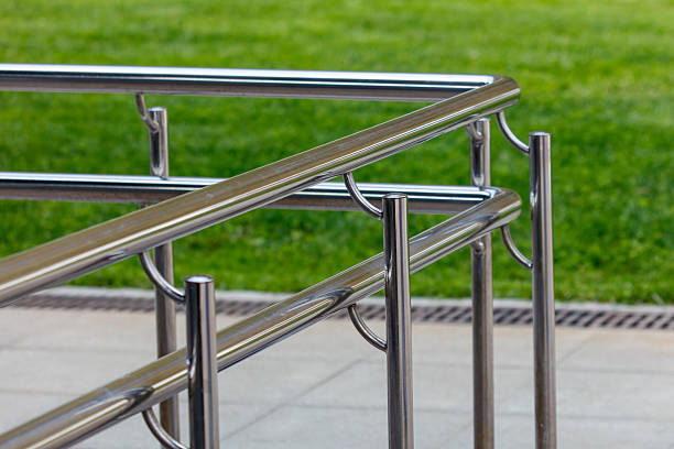 A metal railing with a green grassy background