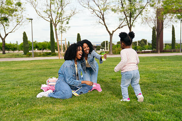 istock Two mothers playing with their daughter in the park 2217334142