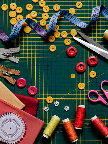 istock Green cutting mat and sewing accessories. Buttons, threads. cloth, meashuring tape, zippers and scissors. Top view. Copy space. 2217335242