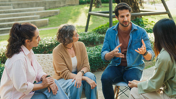 istock Diverse group people engaging in supportive group therapy session, sharing personal stories and advice to promote mental health and recovery in park. Mental health community concept. 2217337639