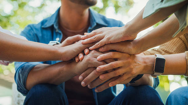 Closeup diverse group people engaging in supportive group therapy session, sharing personal stories and advice to promote mental health and recovery in park. Mental health community concept.