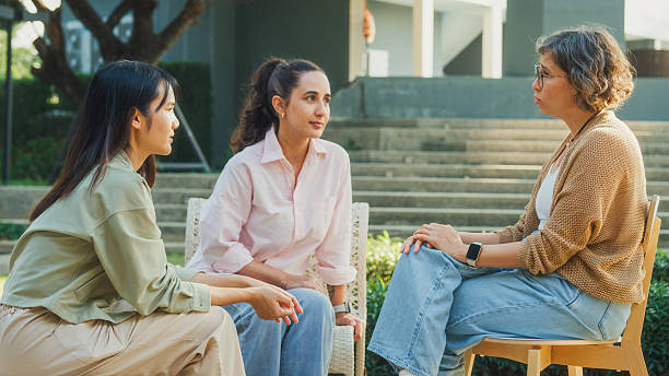 istock Diverse group people engaging in supportive group therapy session, sharing personal stories and advice to promote mental health and recovery in park. Mental health community concept. 2217337728