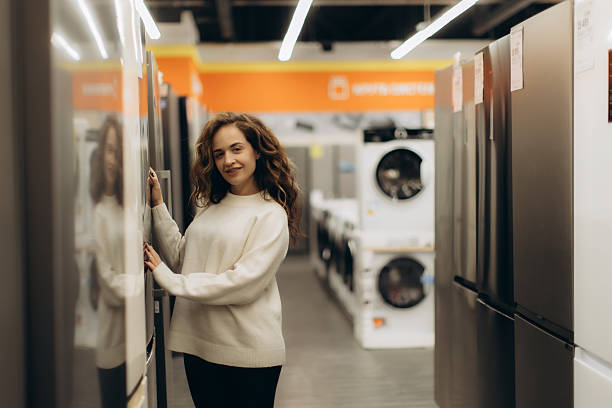 istock Young Woman Shopping for Refrigerators in Modern Electronics Store 2217338179