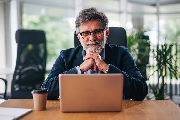istock Senior businessman working on laptop in modern office 2217338529