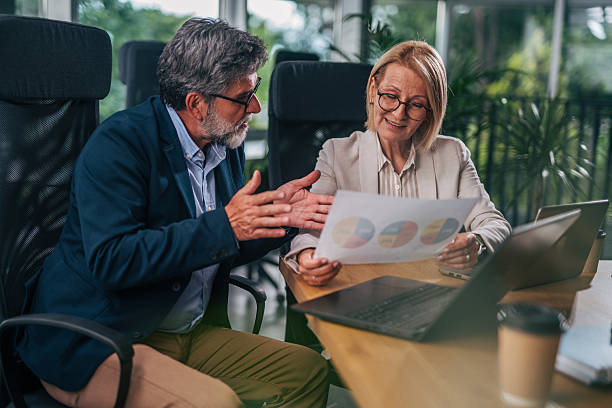 istock Senior business colleagues discussing charts in modern office 2217338601