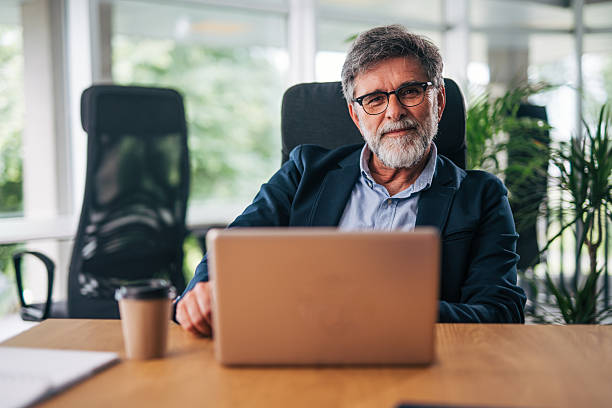 istock Senior businessman working on laptop in modern office 2217338627