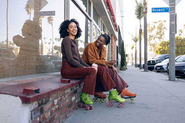 Two friends on roller skates enjoying a ride together.