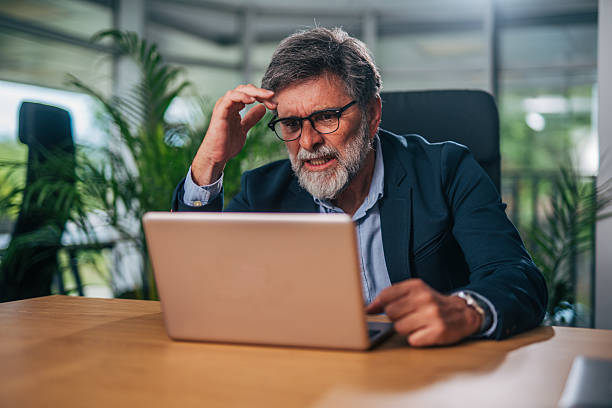 istock Stressed senior businessman having problems with laptop at work 2217339435