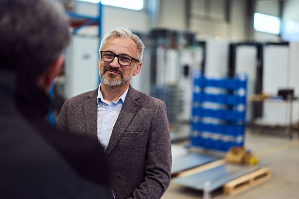 istock Smiling Professional in Industrial Workshop Engaging in a Thoughtful Conversation 2217345084