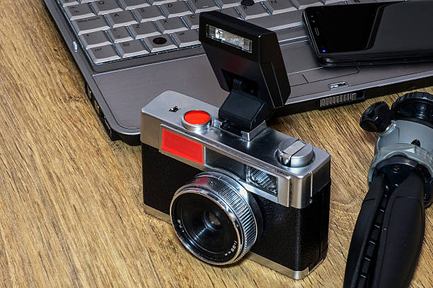 istock An old camera with a flash, mobile phone, tripod and laptop keyboard are lying on the table. 2217345228