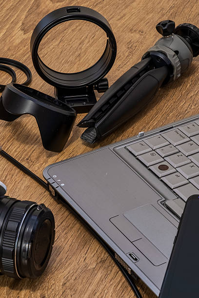 istock Camera lens, tripod, and laptop arranged on a wooden table, ready for content creation. 2217345255