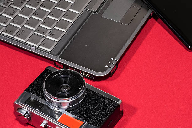 istock A vintage camera sits next to a laptop and smartphone on a vibrant red backdrop, creating a tech-forward aesthetic. 2217345354