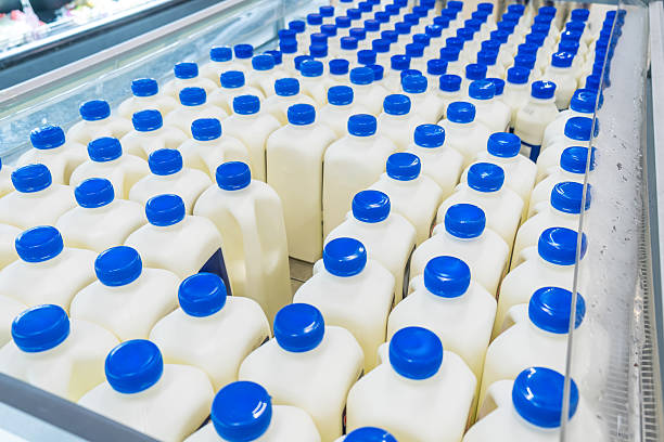 istock Plastic bottles of fresh milk arranged in neat rows inside refrigerated display case in supermarket. Food distribution, mass production, and consumer choice in grocery store. Dairy industry and retail 2217345653
