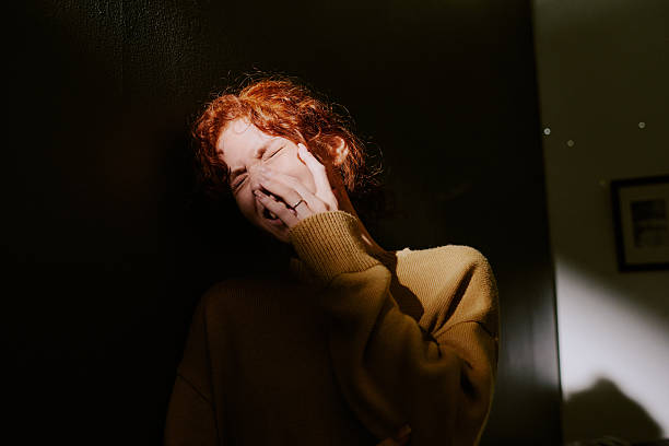 istock Depressed Woman in Warm Indoor Setting Covering Mouth 2217347151