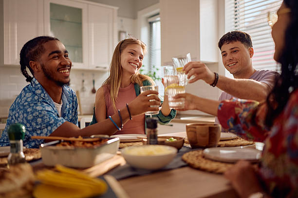 istock Young happy friends toasting during lunch at dining table. 2217347842