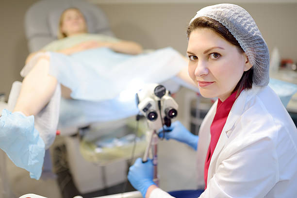 istock Gynecologist examines a patient using microscope in a gynecological chair. Doctor performs a colposcopy on a young girl in a modern medical office. 2217347963