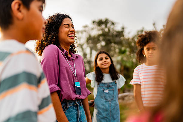 istock Young teacher talking to child students during field trip on zoo 2217349481