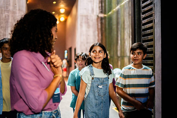 istock Young teacher walking and talking to students during field trip 2217349500