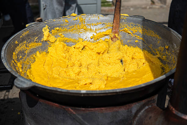 Traditional Moldovan and Romanian mamaliga cornmeal porridge in large pot at outdoor festival Traditional Moldovan and Romanian mamaliga cornmeal porridge in large pot at outdoor festival. High quality photo mamaliga stock pictures, royalty-free photos & images