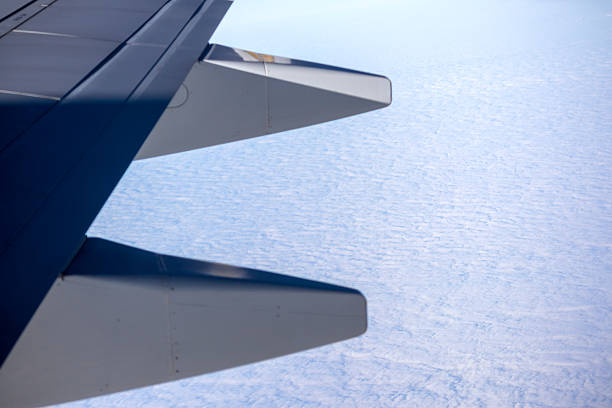 part of an airplane wing above white clouds